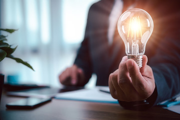 businessman holding a light bulb businessman holding a light bulb